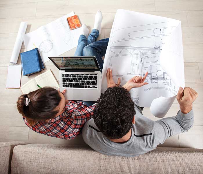 Man and women working on sofa with renovation plans